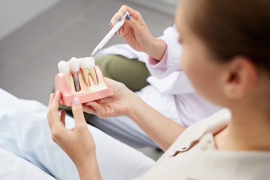 Dentist Showing Patient How A Dental Implant Procedure Works